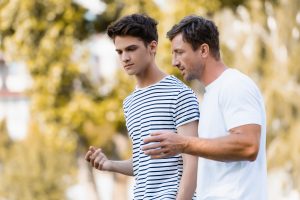A teenager and Kinship Carer walk in the park talking